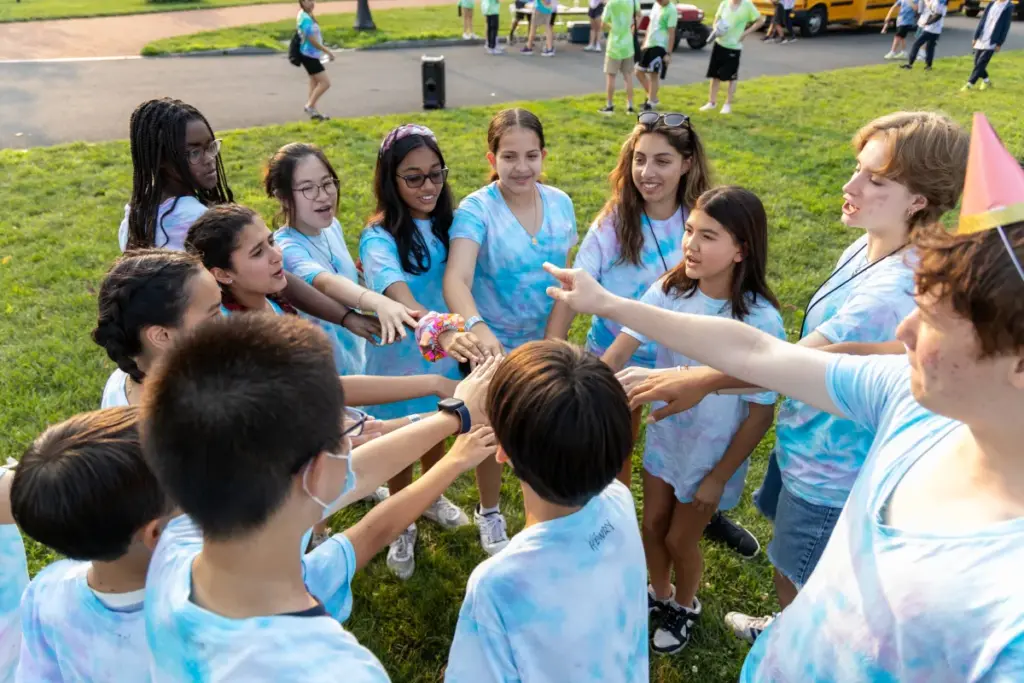 Middle school students putting their hands together for a cheer at Peddie Summer Academy