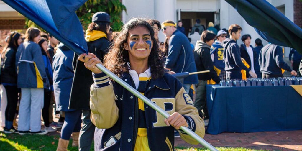 student waving a Peddie flag