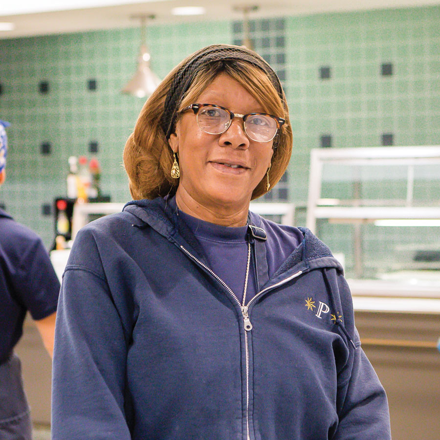 Cheryl Jamison prepares the daily menus on the white boards in the dining hall serving area.