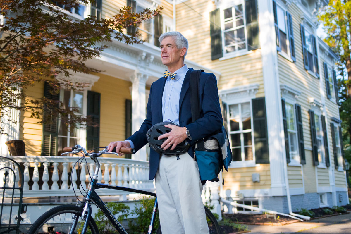 Peter Quinn standing with his bicycle outside of his home