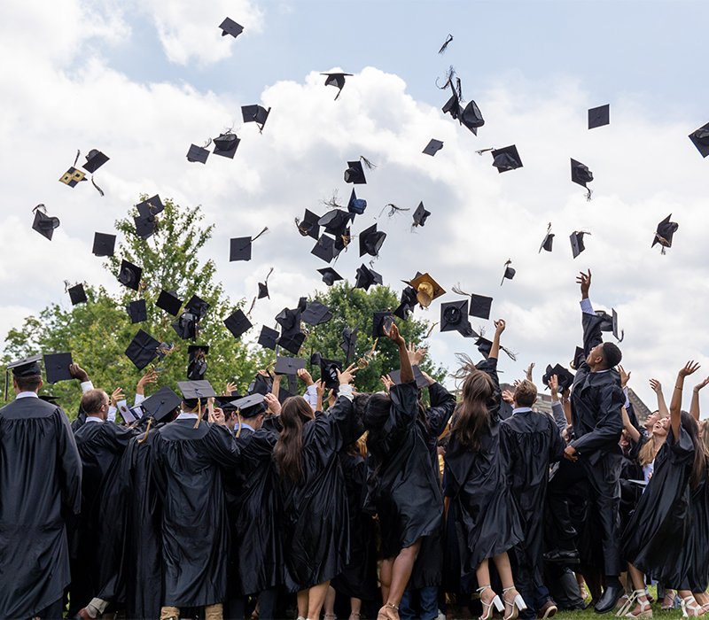 students throwing their caps in the air
