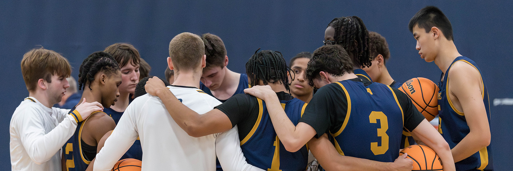 The Peddie varsity boys basketball team huddles
