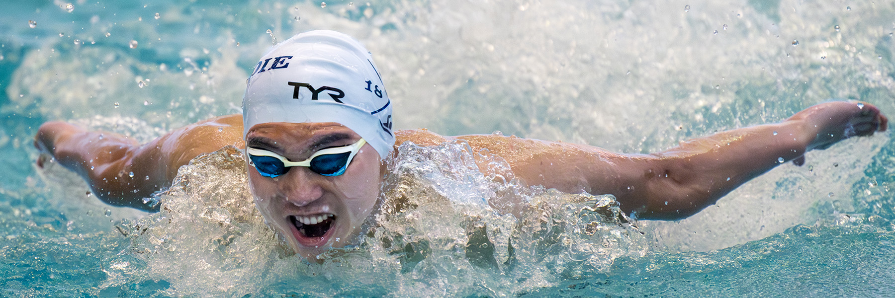 A Peddie varsity boys swimmer races