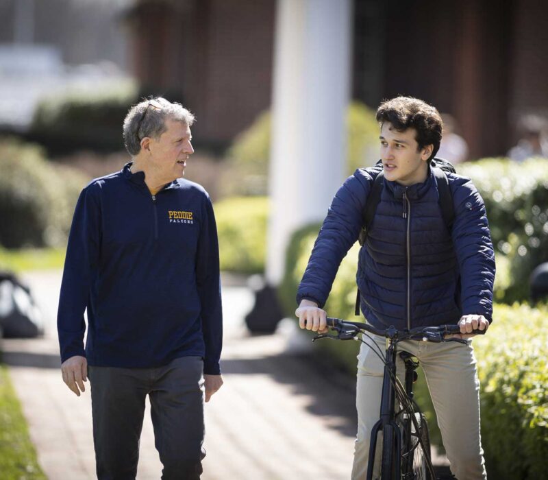 Peddie teacher walking with student on bike